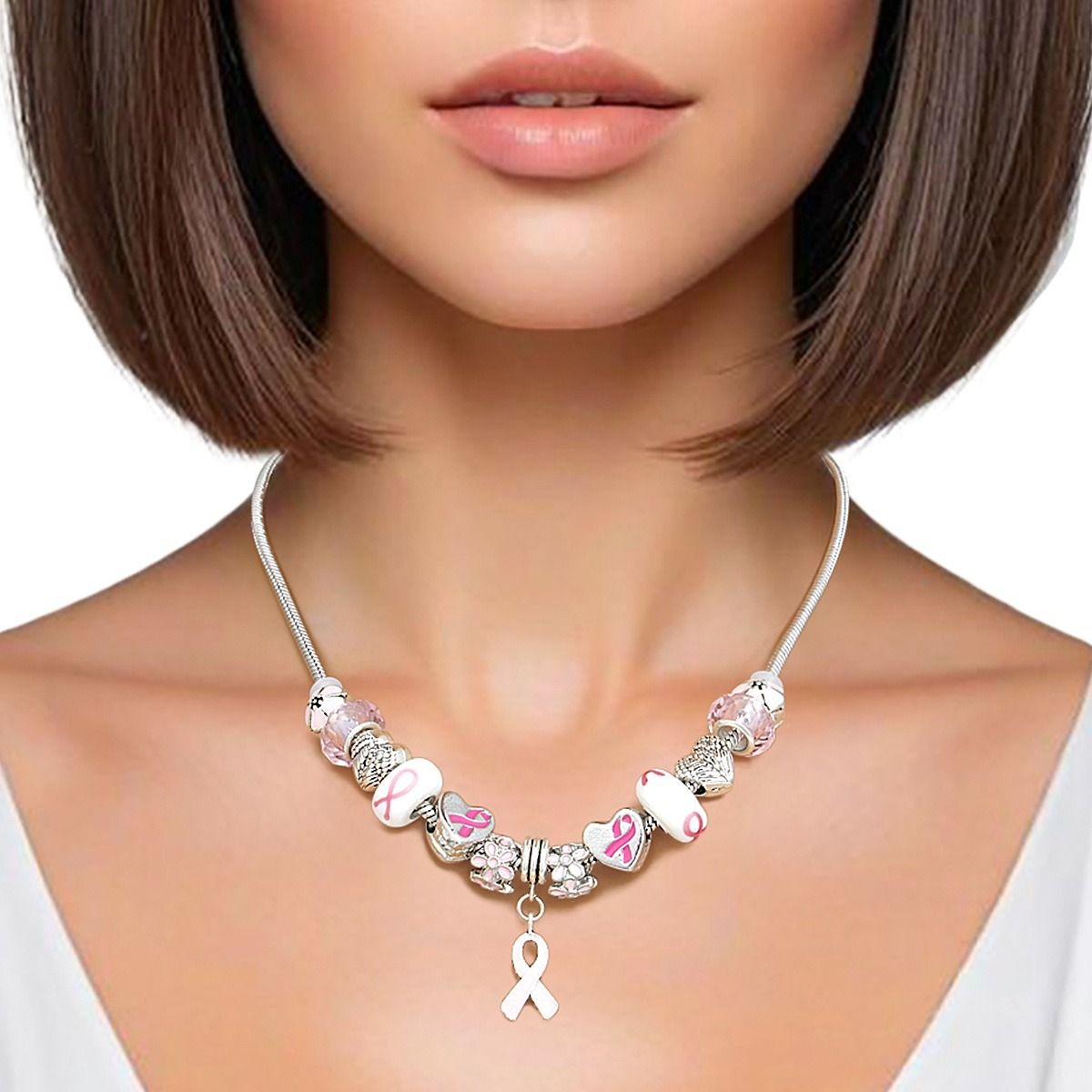 Woman wearing a pink ribbon charm bead necklace on a silver snake chain, with the light pink ribbon charm centered at the neckline