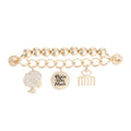 Gold Black Girl Magic phone wrist strap laid flat on white background, showing gold metal ball bead strand and gold curb chain with three charms: rhinestone afro woman silhouette, round engraved Black Girl Magic disc with rhinestone border, and ivory afro pick comb charm