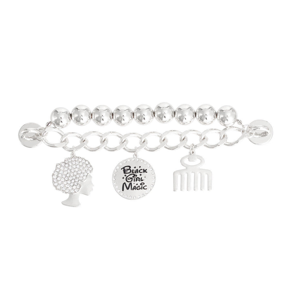 Silver Black Girl Magic phone wrist strap attached to pink iPhone case, featuring polished silver metal ball beads on silver curb chain, rhinestone afro woman silhouette charm, round Black Girl Magic engraved disc charm with rhinestone border, and silver afro pick comb charm