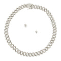 Overhead flat lay of a wide silver tone fully pave clear rhinestone square Cuban chain link necklace arranged in a circle on a white background. A square push-lock box clasp covered in clear rhinestones with a safety latch is visible at the top. Two small clear rhinestone round stud earrings with clear rubber butterfly post backings are displayed inside the necklace loop.