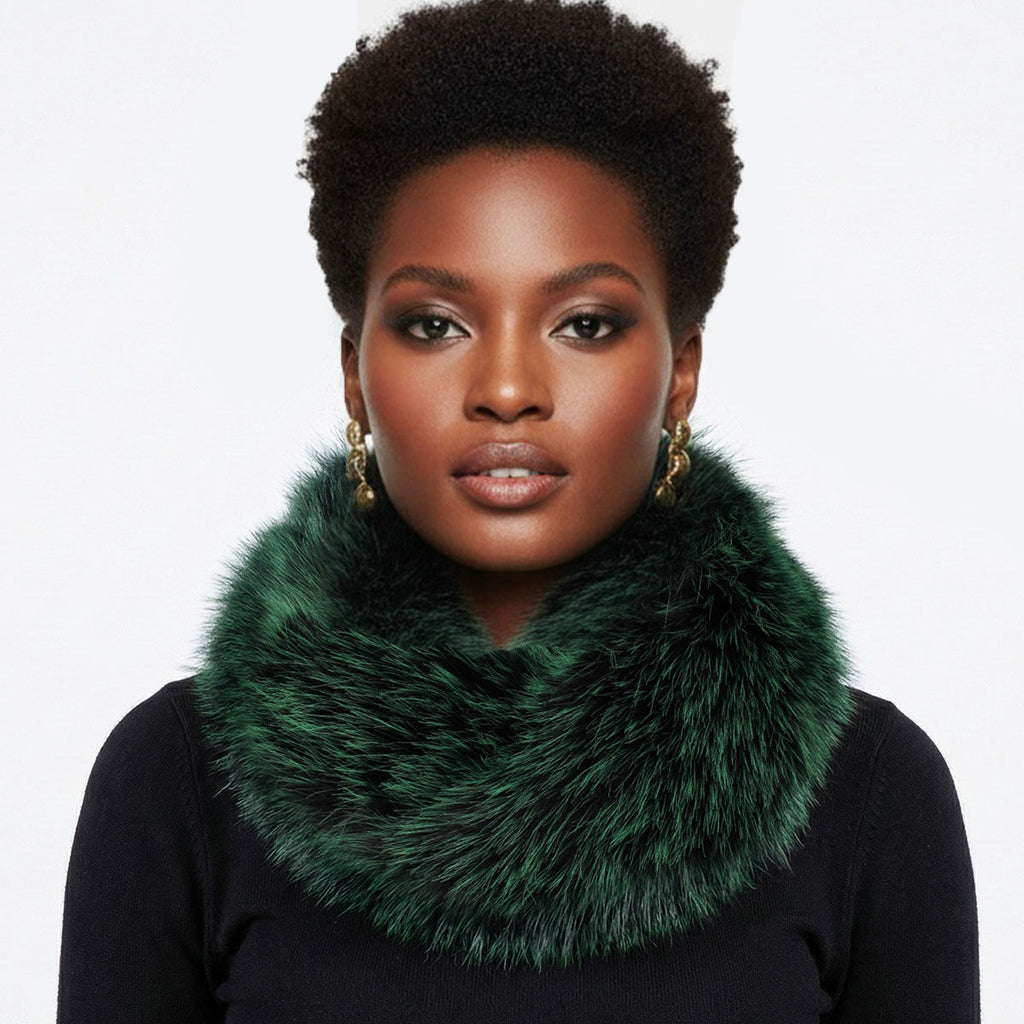 Close-up of a model wearing an emerald green faux fur scarf wrapped around her neck over a black sweater, with gold-tone earrings against a pale background