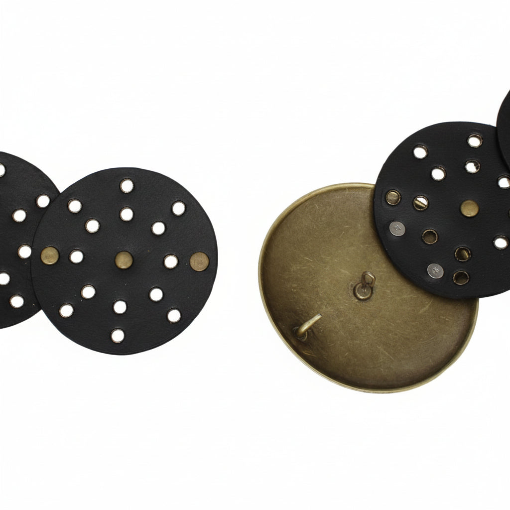 Back view of black vegan faux leather western concho belt showing underside of circular disc panels with punch-out holes and gold rivet hardware, hook closure mechanism on back of distressed gold round buckle, white background