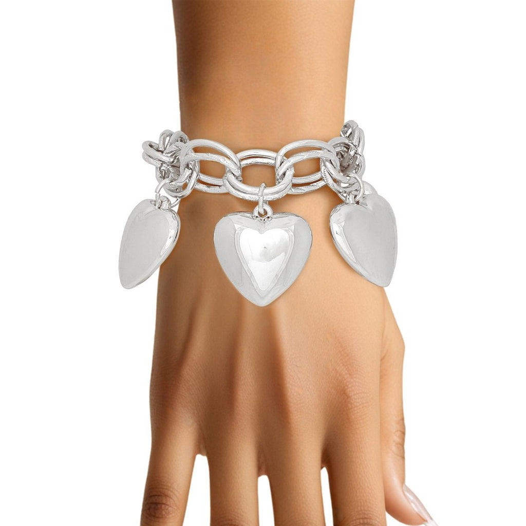 Chunky silver-tone double oval link chain bracelet with five oversized polished puffy acrylic heart charms worn on a model's wrist, white background