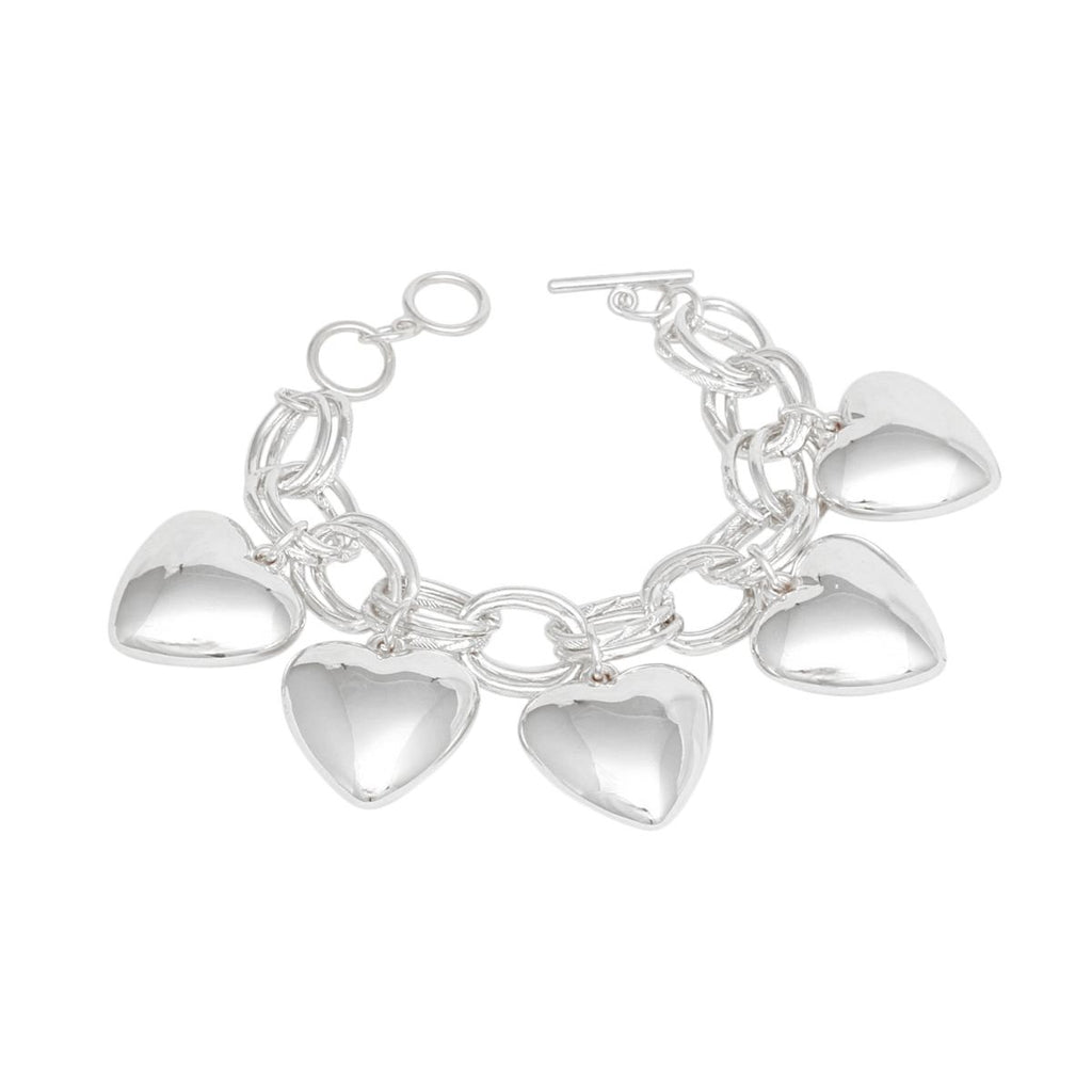 Women's silver-tone chunky heart charm toggle bracelet laid flat showing circle-and-bar toggle closure and five large hollow puffy heart charms dangling from double oval link chain, white background