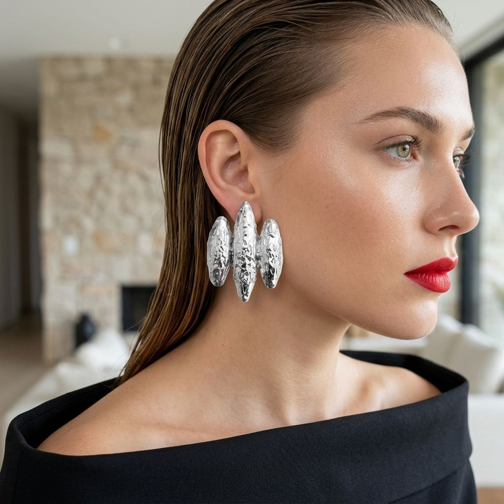 Model wearing silver textured triple-rib clip-on earrings with a sculptural 1980s-inspired design.