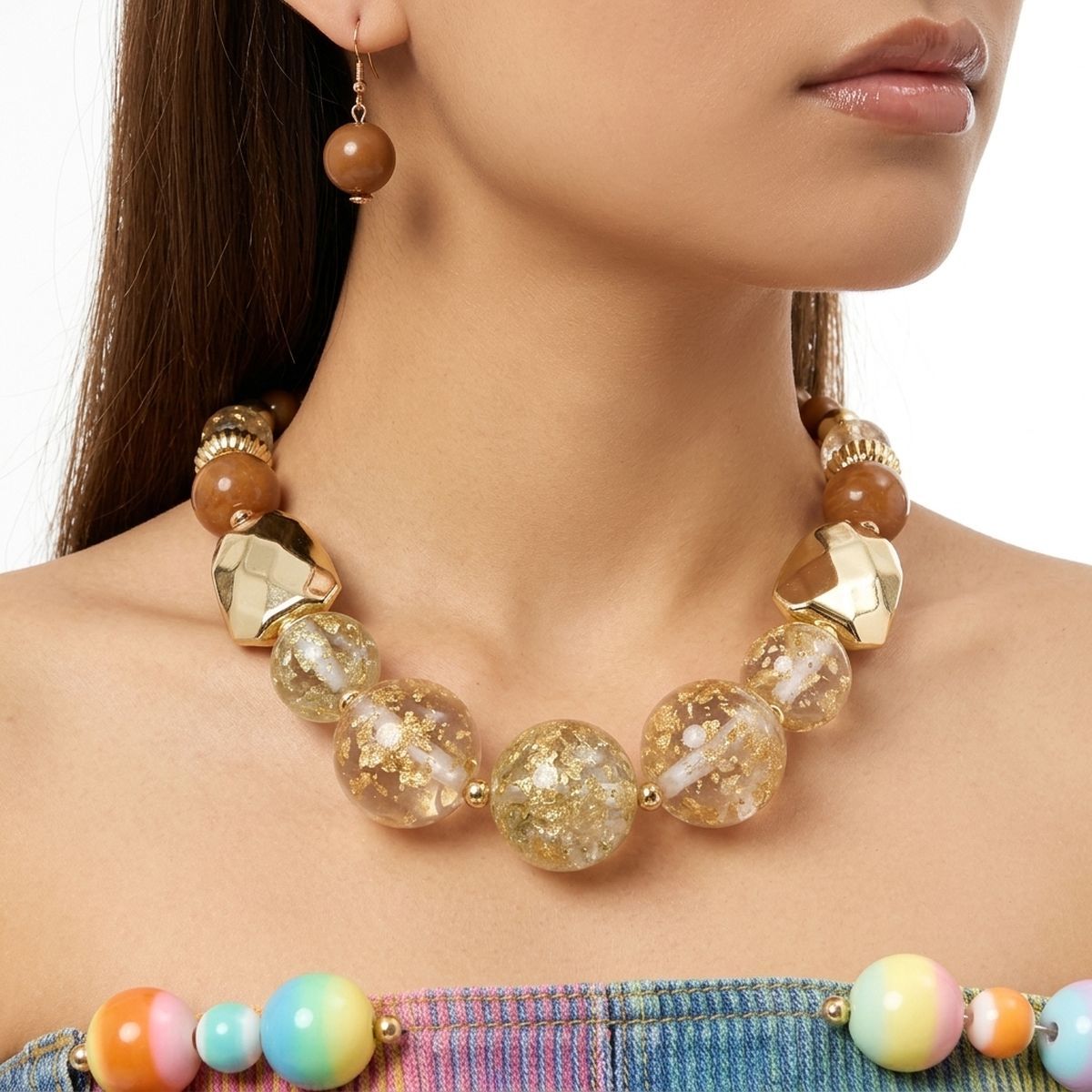 Close-up of brown bead necklace and earrings with oversized clear resin beads filled with gold-flake accents