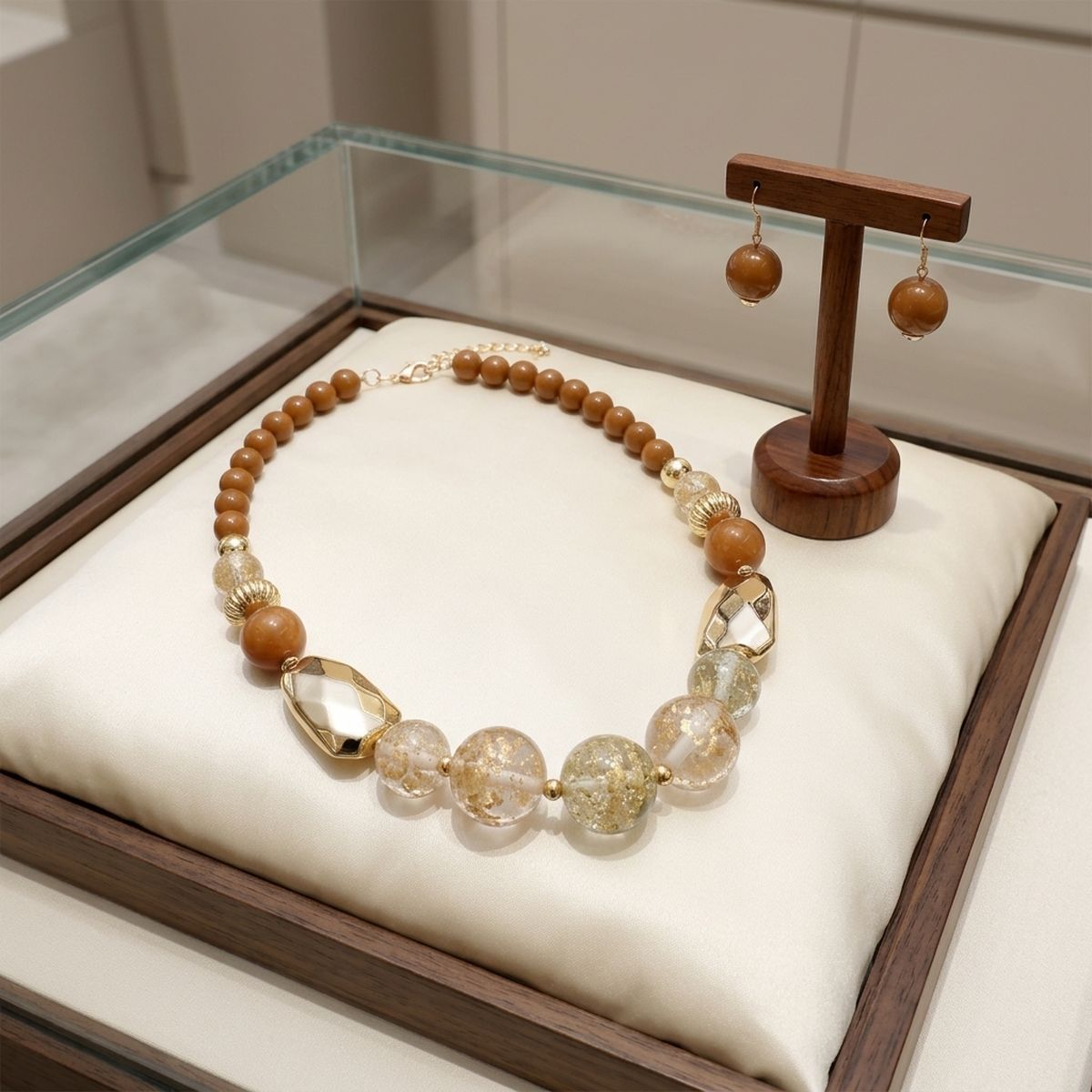 Brown gold-flake resin necklace and matching drop earrings displayed in a wooden jewelry case