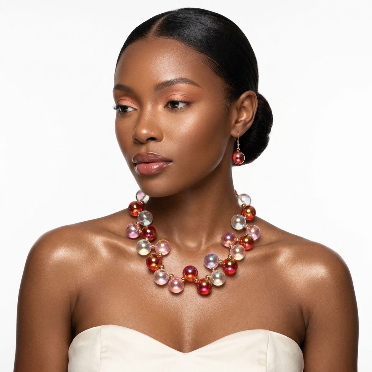 Woman wearing a red and pink iridescent bubble-bead necklace with gold spacers and a matching drop earring