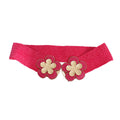 Fuchsia wide woven raffia stretch belt laid flat and open on white background, double gold basket-weave flower hook closure showing two five-petal flowers with gold crosshatch texture centers, fuchsia raffia petal surrounds with gold beaded trim edging and center hook mechanism, full woven raffia body visible