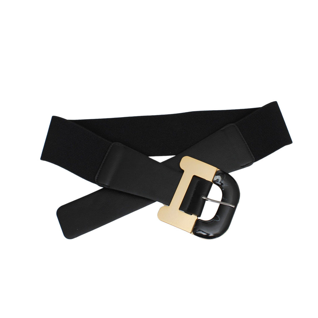 Black wide stretch belt crossed and laid flat on white background, smooth black vegan faux leather front panel, oversized two-tone buckle with gold metal frame and black marbled acrylic rounded insert with silver pin closure, black elastic stretch canvas back