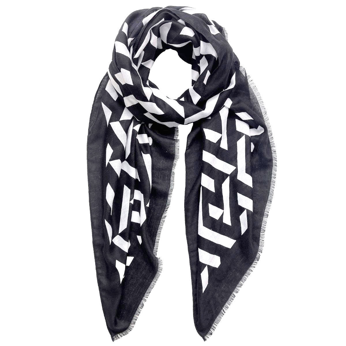Black-and-white geometric print scarf loosely looped against a white background, showing its black border and fine frayed edges