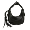 Front view of a black rounded faux-leather shoulder bag with a knotted handle, curved silver-tone zipper and long fringe hanging from one side, on a white background