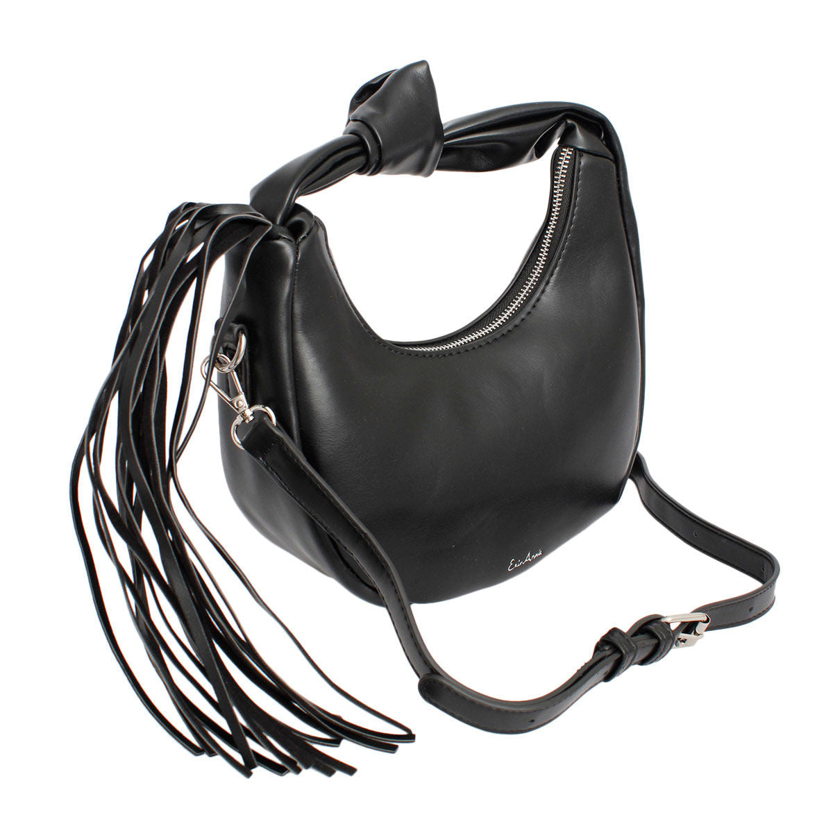 Angled view of a black round fringe handbag showing its knotted handle, silver-tone zipper and attached adjustable crossbody strap, on a white background