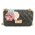 Front view of black diamond-quilted jelly bag with pink, pale blue, and cream flower appliqués, a gold-tone twist lock, and chain strap on a white background