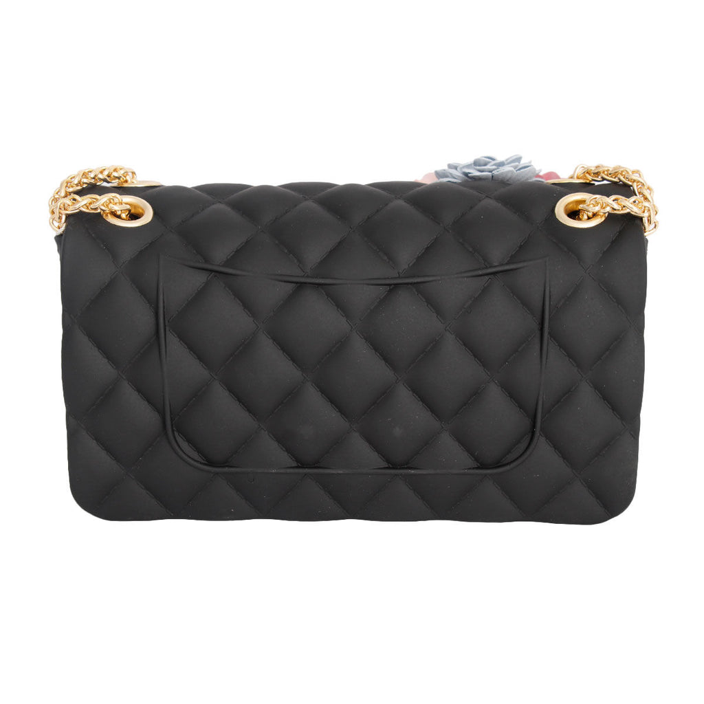 Rear view of black diamond-quilted jelly bag with a large slip pocket, gold-tone chain attachments, and round gold-tone eyelets on a white background