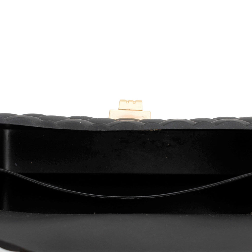 Close-up of the black jelly bag’s open interior showing a curved slip compartment and gold-tone closure hardware against a white background