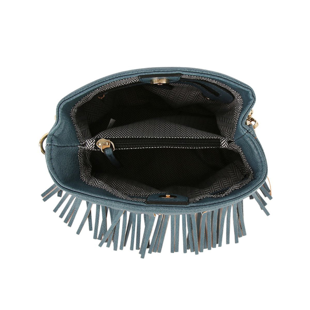 Open denim-blue fringe handbag showing herringbone-patterned lining, a zippered center compartment, and magnetic snap closure