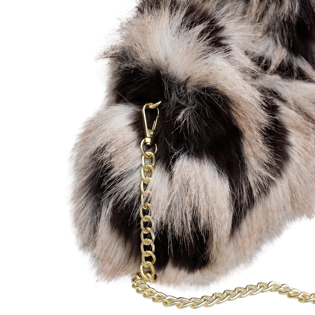 Close-up of the cream-and-black faux-fur bag showing its gold-tone chain clasp attached at the side
