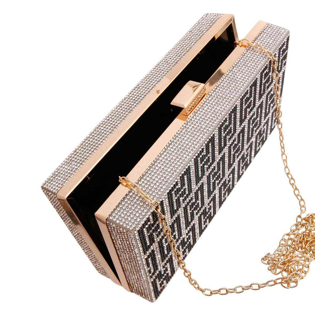 Open black-and-silver rhinestone Greek-key hardcase clutch showing its dark interior, gold-tone frame and detachable chain on a white background