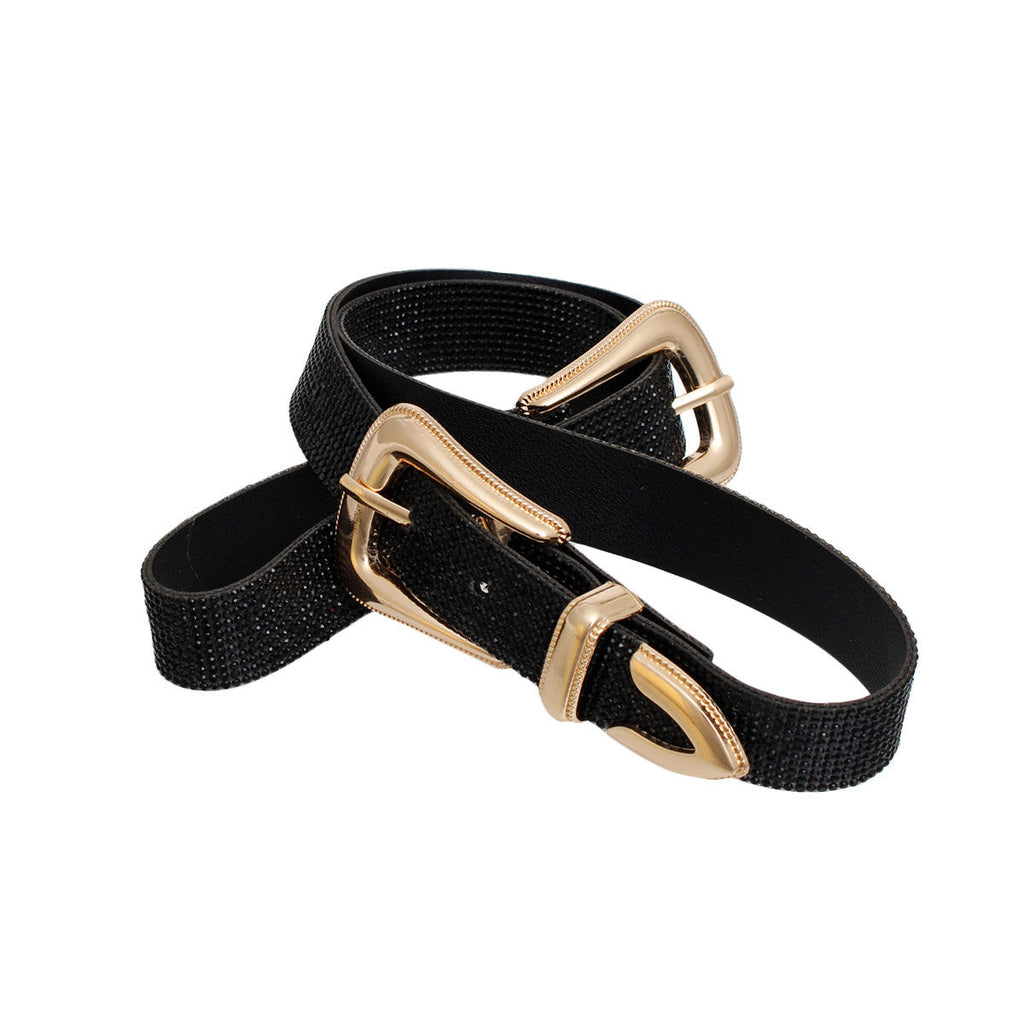 Full black rhinestone double buckle western belt laid flat on white background, full length view showing two gold metal western buckles with pointed arrow tip hardware at each end, complete micro black crystal stone coverage across 1-inch wide black vegan leather belt, punch-out holes visible along center