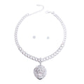 Full set on white background — rhinestone-encrusted silver Cuban link chain necklace with a large 3D rhinestone-covered lion head pendant, lobster clasp and extender chain visible, with two small round clear rhinestone stud earrings centered inside the necklace