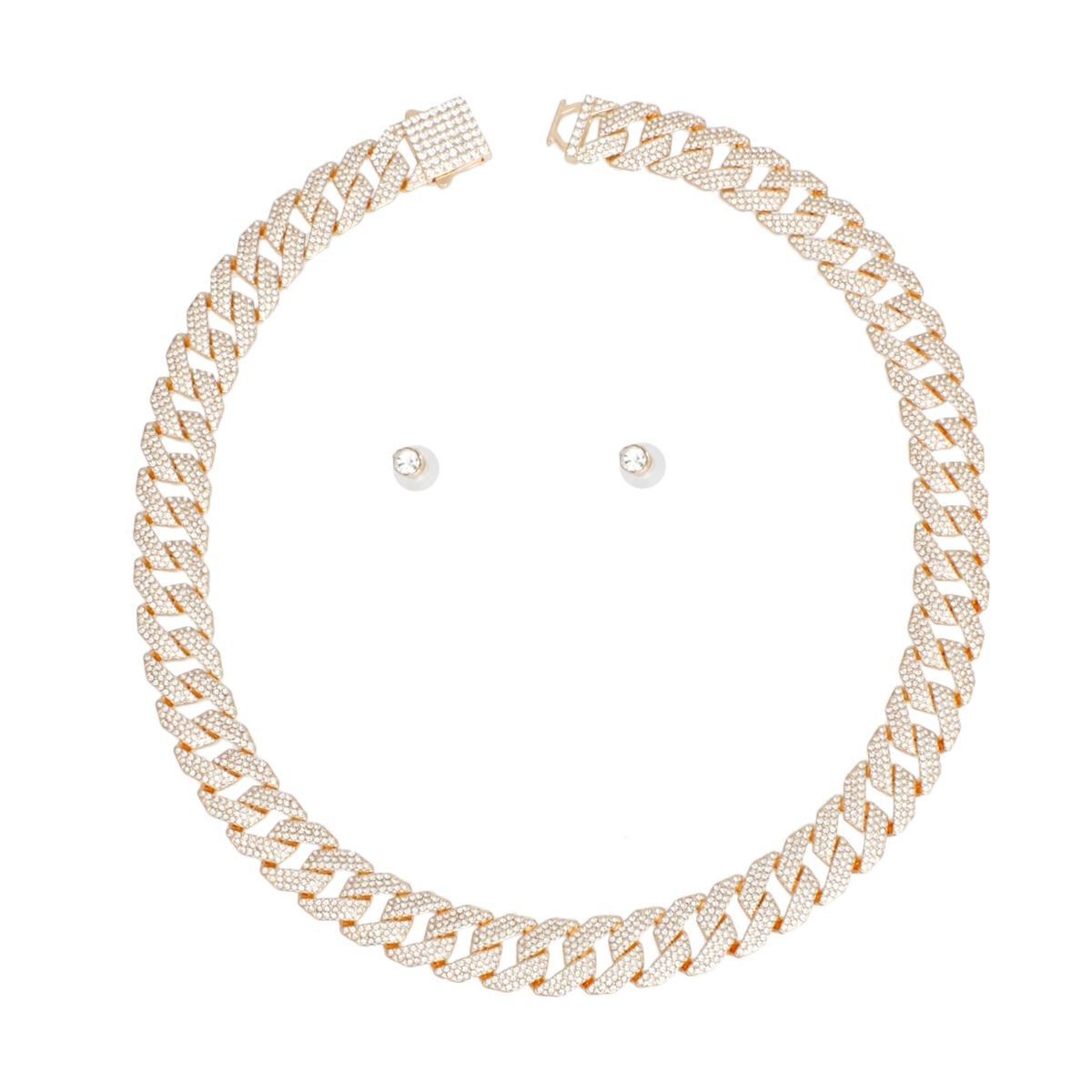Overhead flat lay of a wide 14mm fully pave clear rhinestone Miami Cuban chain link necklace in gold tone arranged in a circle on a white background. A square push-lock box clasp covered in clear rhinestones is visible at the top with a safety latch. Two small round clear rhinestone stud earrings with butterfly post backings are displayed inside the necklace loop.