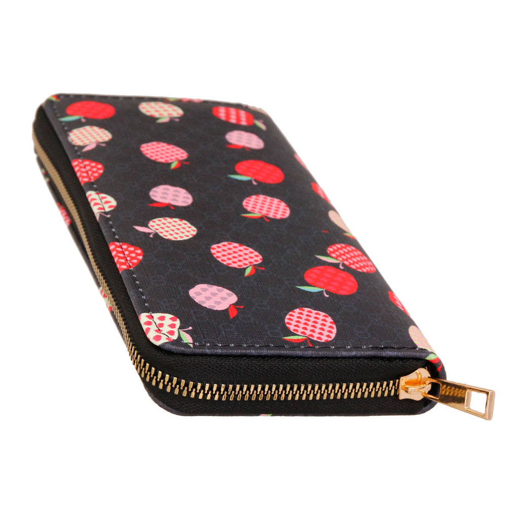 Black woven zipper wallet wristlet with scattered red and pink multicolor apple print on dark background, gold-tone zipper pull — top-down angled view showing zipper detail