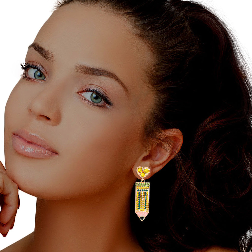 Woman wearing yellow and green rhinestone pencil drop earrings with gold-tone heart stud top and pink enamel tip, lifestyle model shot.