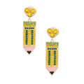 Pair of yellow and green crystal rhinestone pencil drop earrings with gold-tone heart stud top, pink enamel eraser tip, and black rhinestone pencil point, white background product shot.