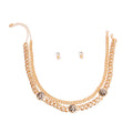 Overhead flat lay of a 2-layer rhinestone pave Cuban chain necklace in gold tone arranged in a U-shape on a white background. Three burnished antique gold coin medallions with a Roman profile face detail measuring 0.75 inches are spaced along the lower chain. A lobster clasp and extender chain are visible at the top right. Two small clear crystal round stud earrings with gold tone post backings are displayed in the center.